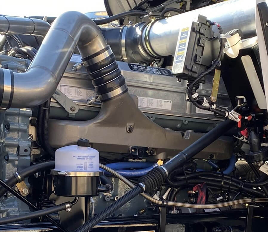 Close-up of a heavy-duty diesel engine with air intake manifold, intake piping, and engine to cab interface.